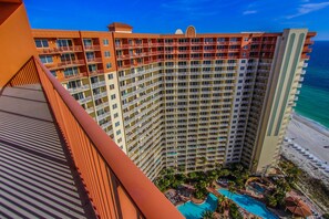 A high-rise hotel with multiple balconies, a pool area, and a beach view. - Shores of Panama Beach Resort (Panama City Beach)