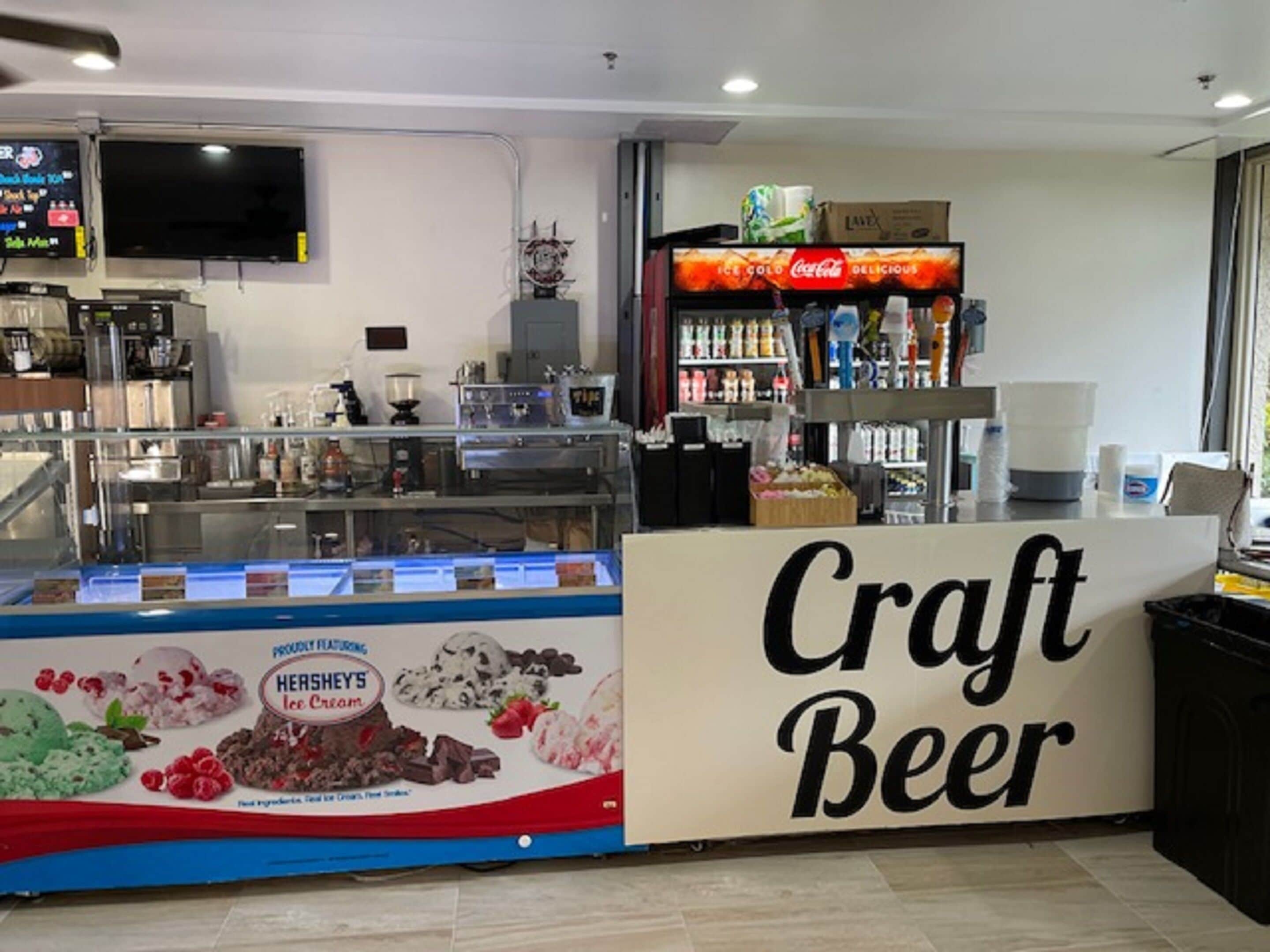 Um bar de cerveja artesanal com um expositor de sorvete Hershey's e uma geladeira Coca-Cola.