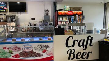 Um bar de cerveja artesanal com um expositor de sorvete Hershey's e uma geladeira Coca-Cola.