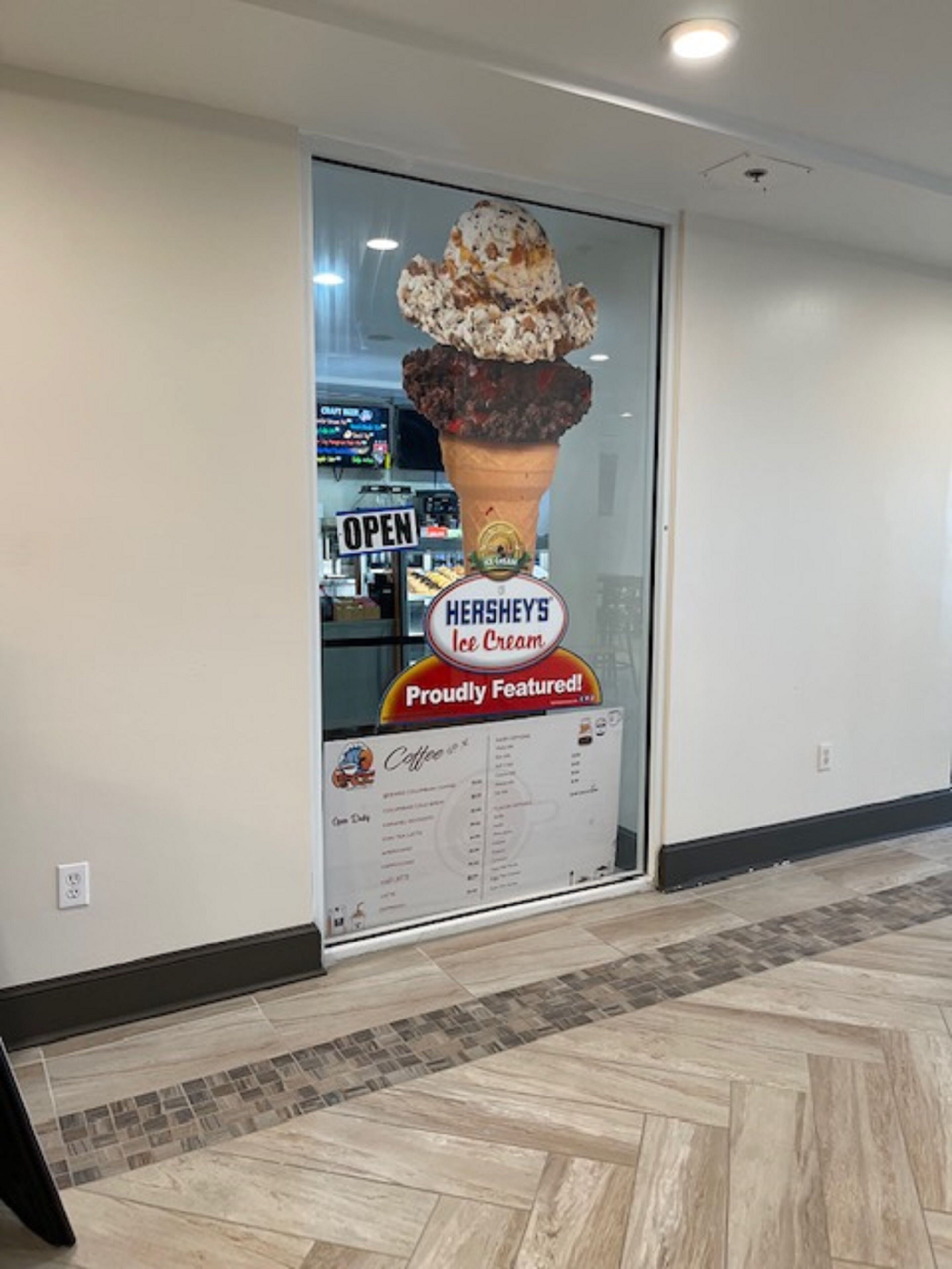 Fachada de loja com grande anúncio de Sorvete Hershey's, exibido em destaque em uma vitrine de vidro.