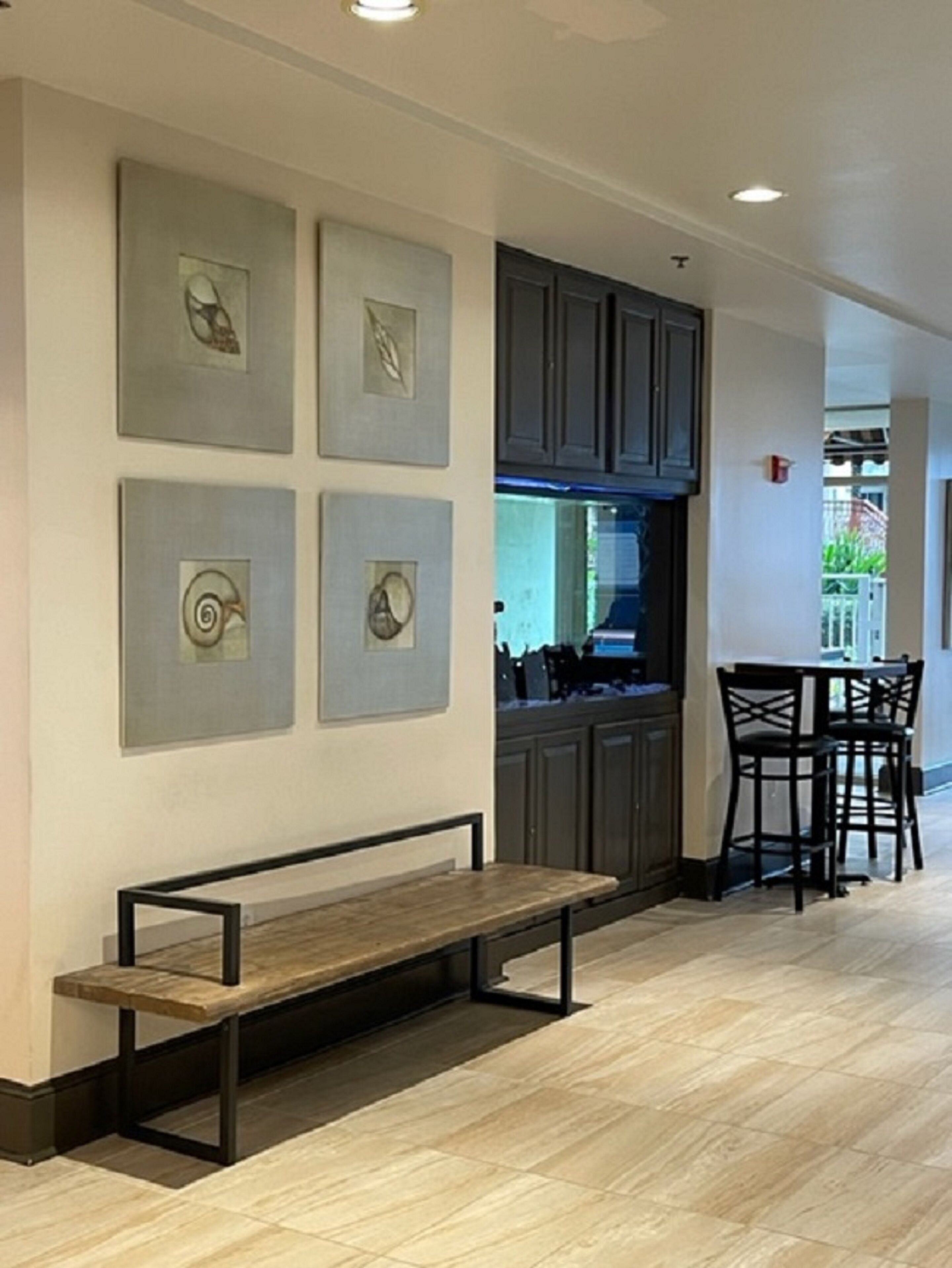 Une cuisine moderne avec des meubles de couleur sombre, un four encastré et un coin repas comprenant une banquette et des chaises.