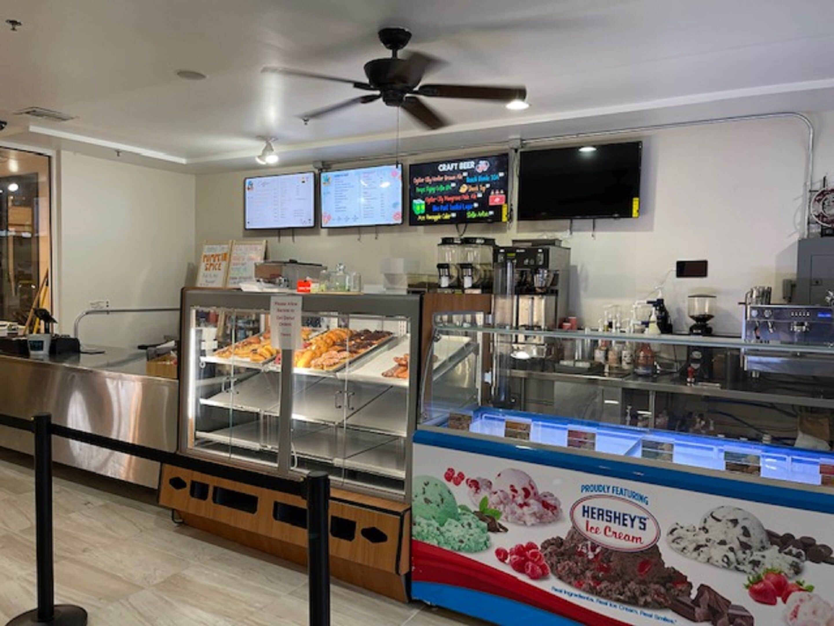A bakery display with various baked goods and a Hershey's ice cream sign.