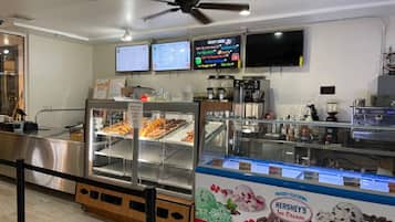A bakery display with various baked goods and a Hershey's ice cream sign.