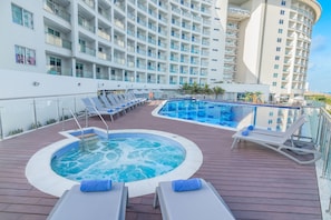Relax by the pool with a hot tub and sun loungers, surrounded by the ship's elegant architecture.