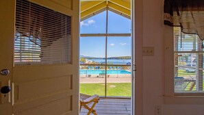 Vista desde una habitación con puerta a un balcón con vistas a la zona de la piscina.