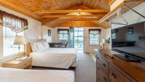 Habitación de hotel con dos camas, un escritorio, un televisor y vistas al exterior.