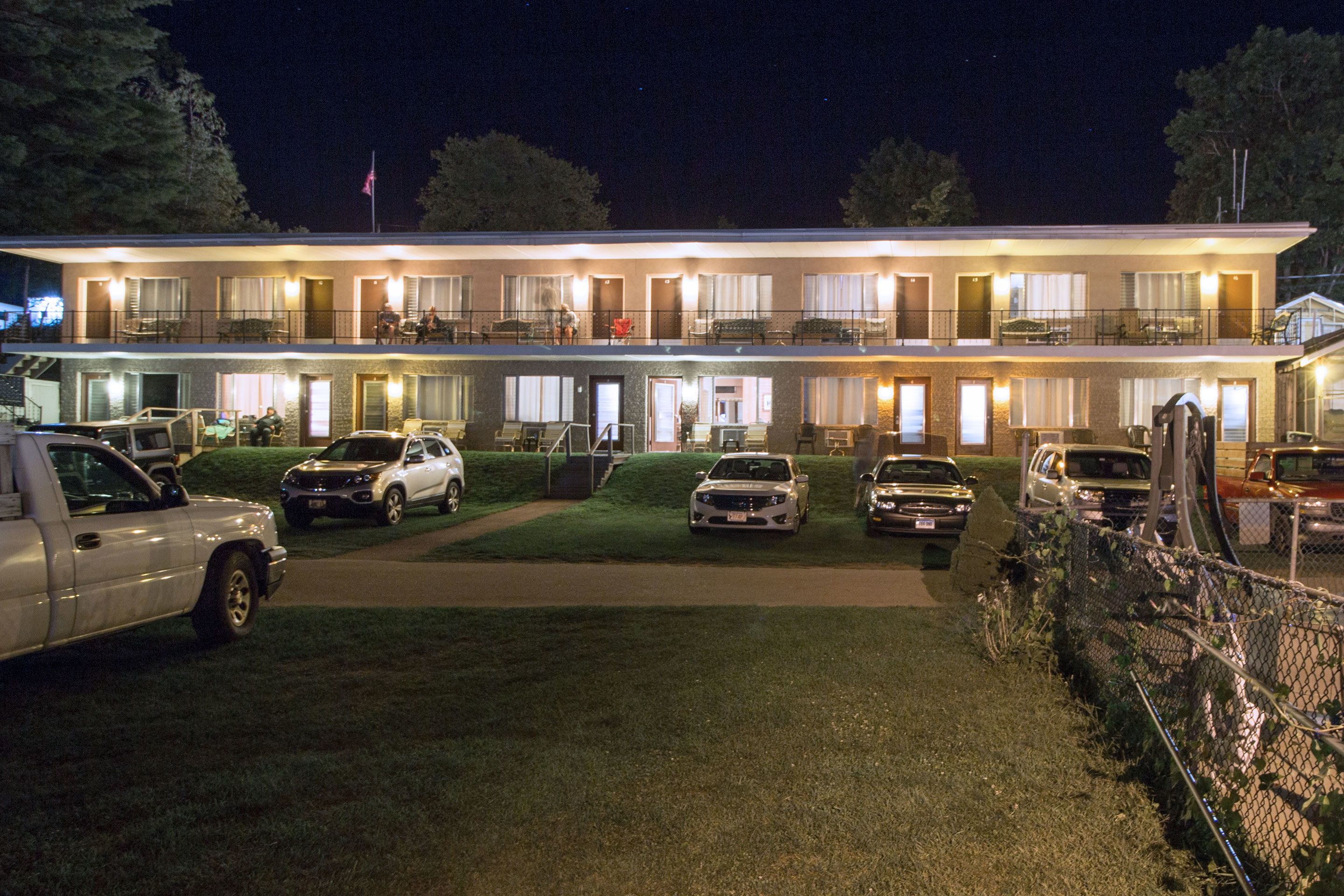 A two-story motel with multiple rooms, a parking area, and a well-lit exterior.