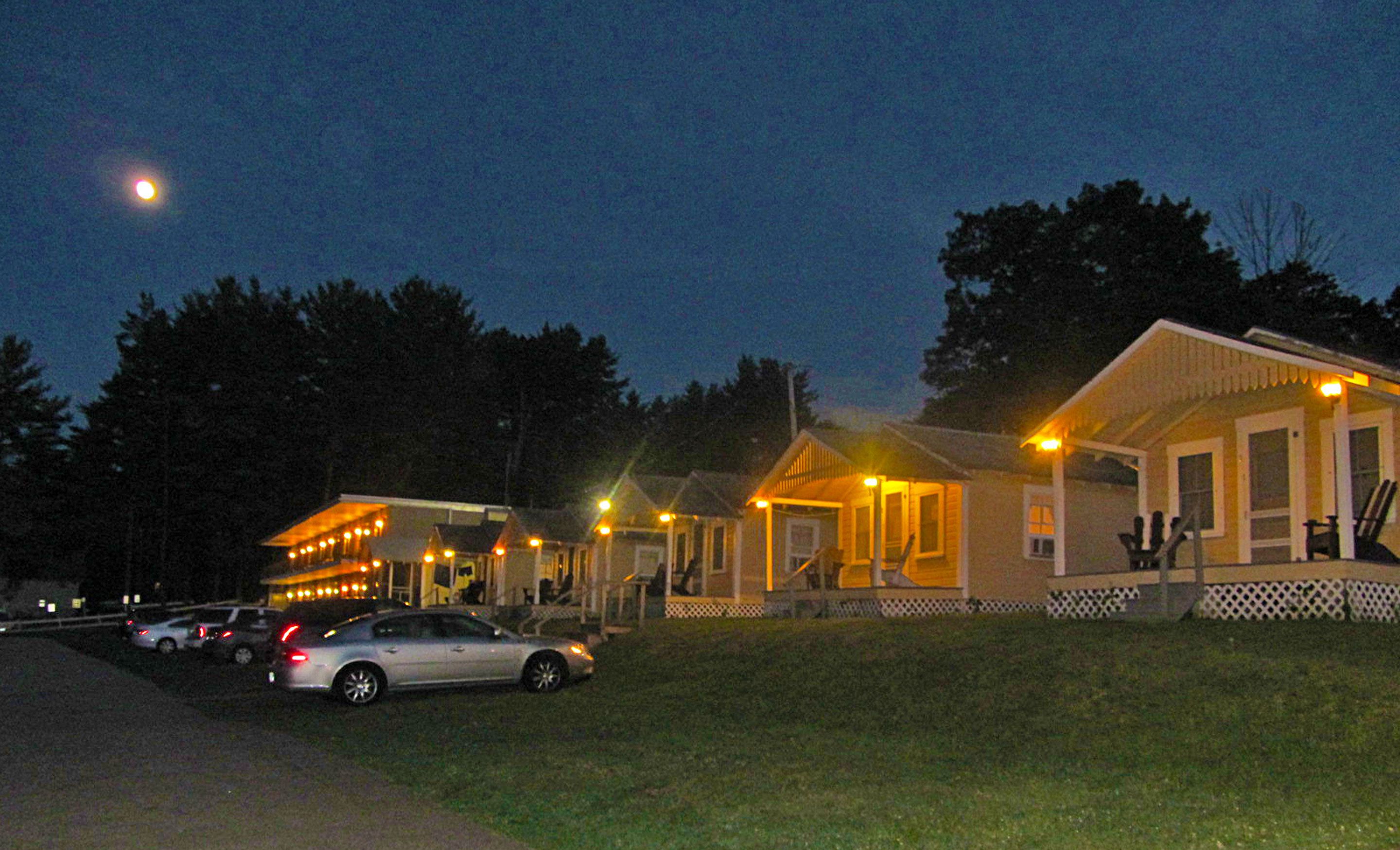 A row of small, single-story buildings with attached porches, likely part of a campground or resort.