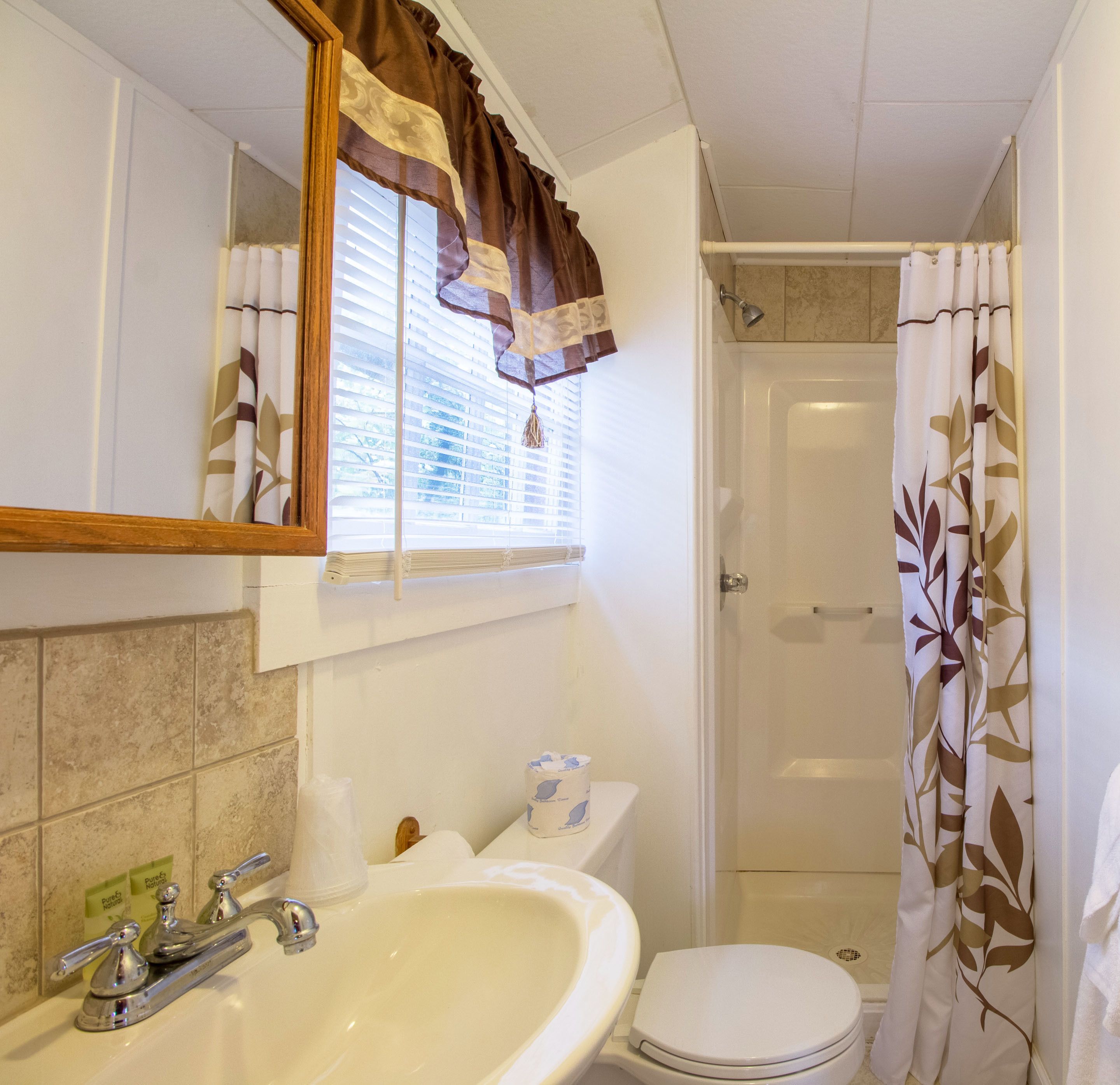 A bathroom with a sink, toilet, and shower.
