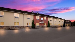 A hotel with a flat facade, multiple windows, and a sign indicating it is a 'SureStay Hotel by Best Western'.