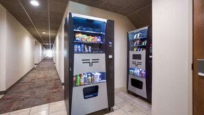 A hallway with vending machines and a carpeted floor.