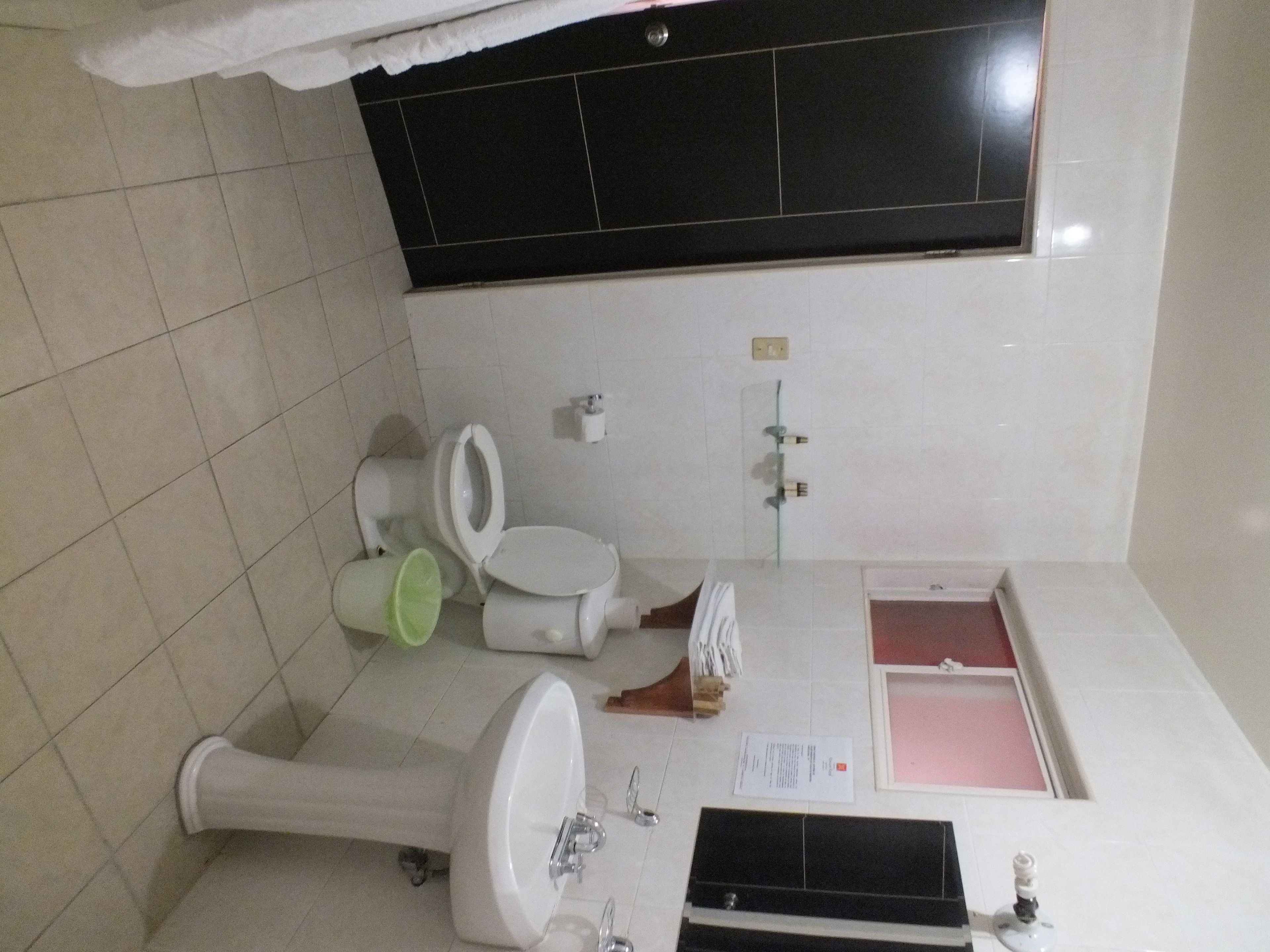 Un bagno con il water, bidet, lavandino e una finestra.