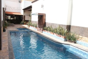 Een buitenzwembad en ligstoelen