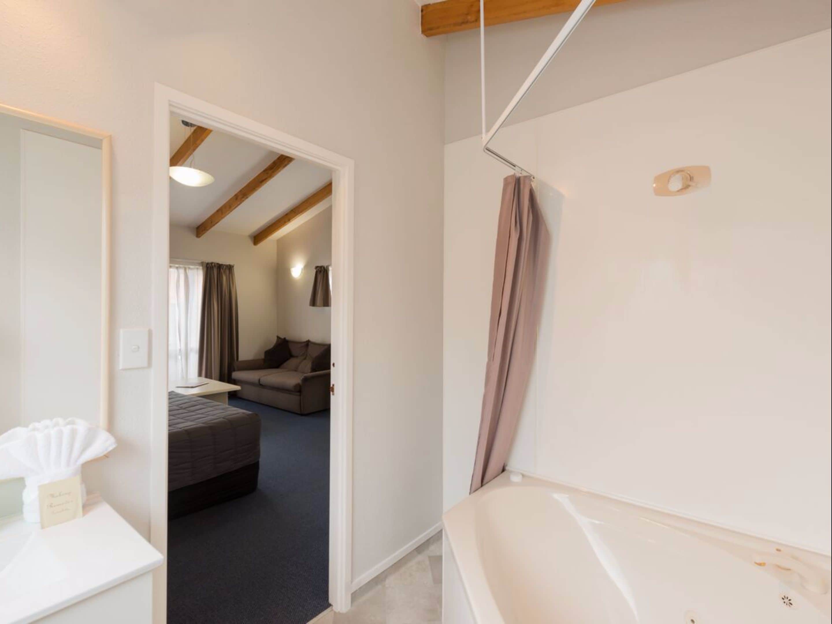 A modern bathroom with a bathtub, a shower curtain, and a visible towel rack.