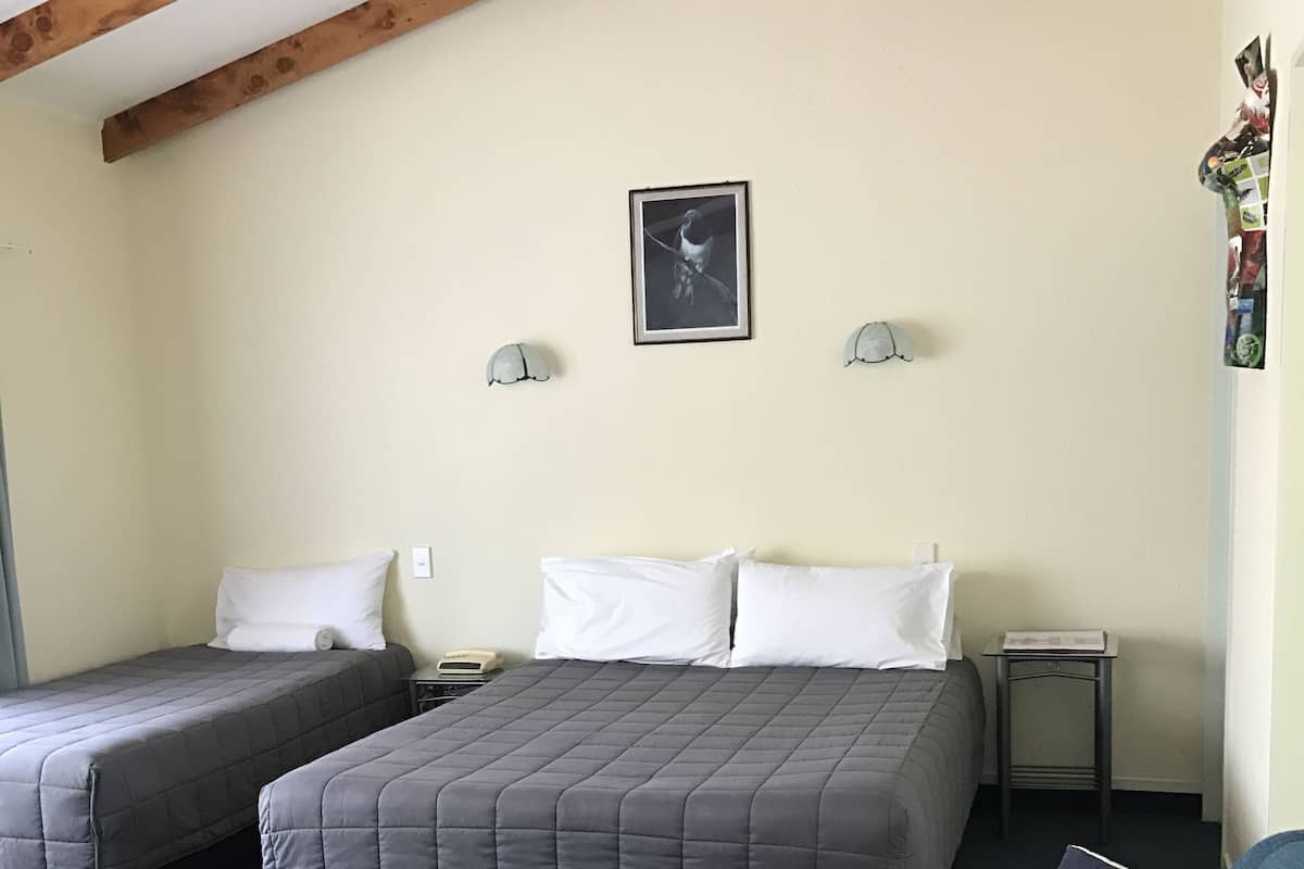 A room with two beds, a sofa, and a small table.