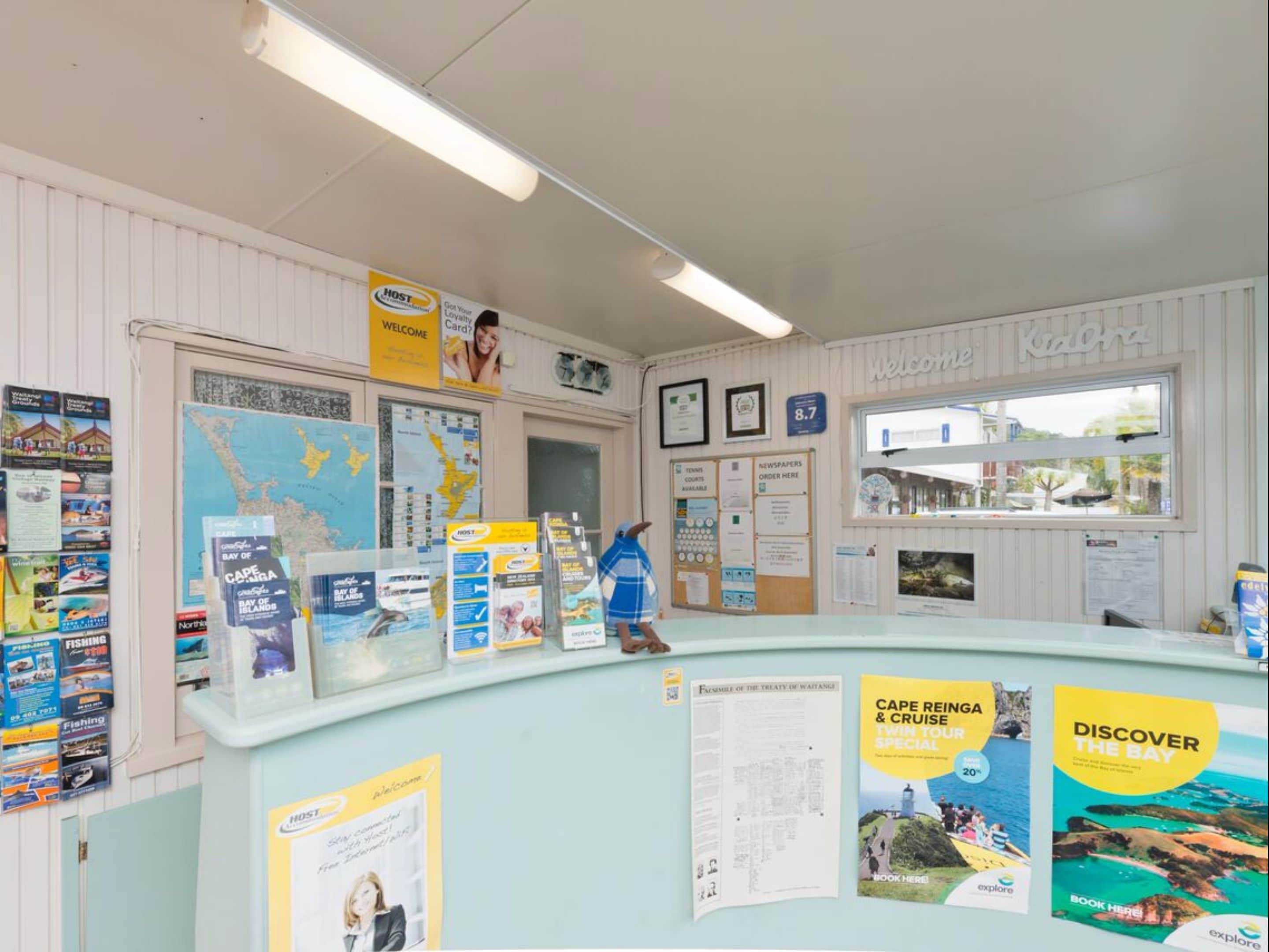 A reception desk with informational brochures, a map, and a welcome sign.