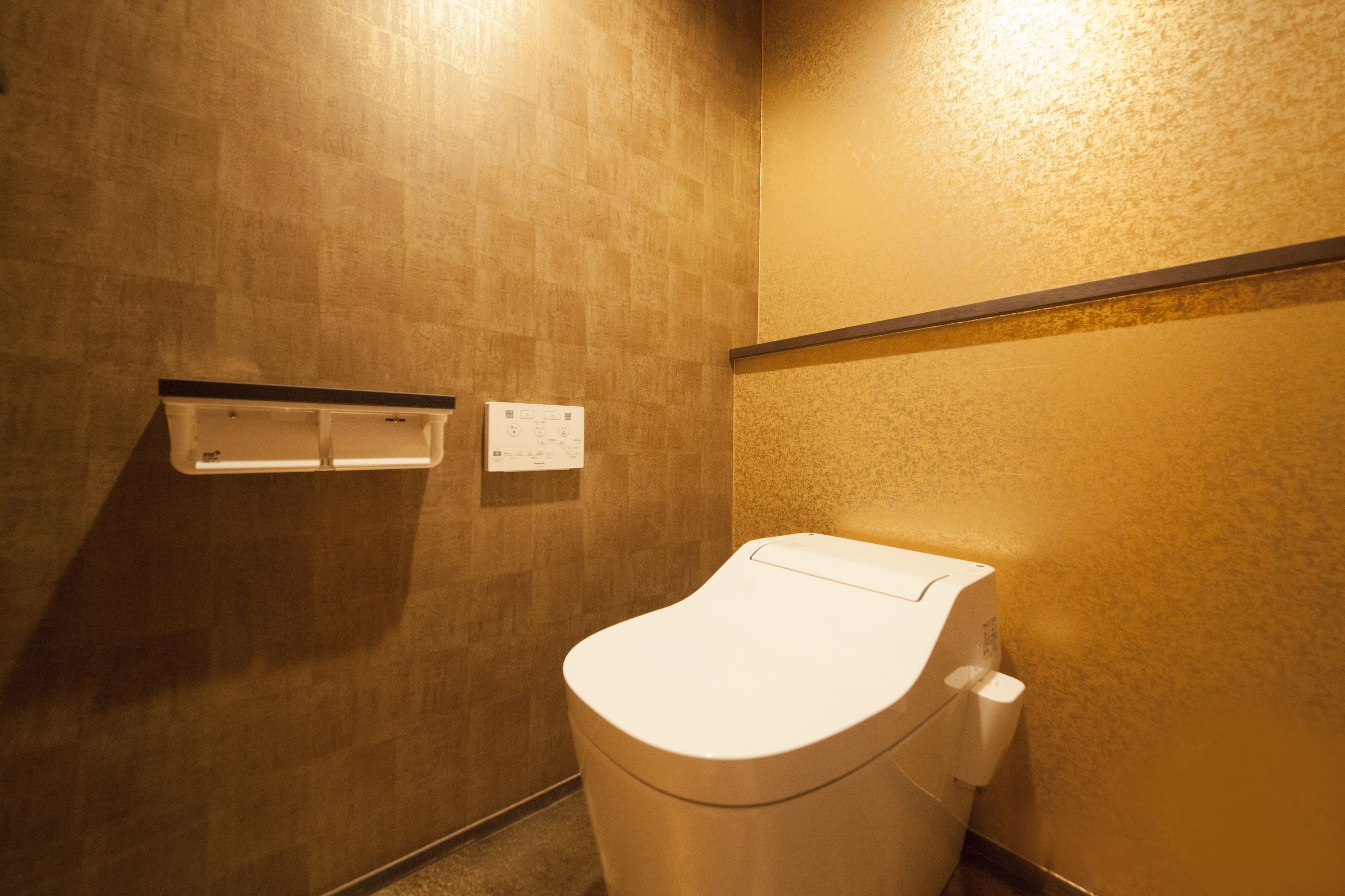 Un baño pequeño y privado, con inodoro y toma de corriente en la pared.