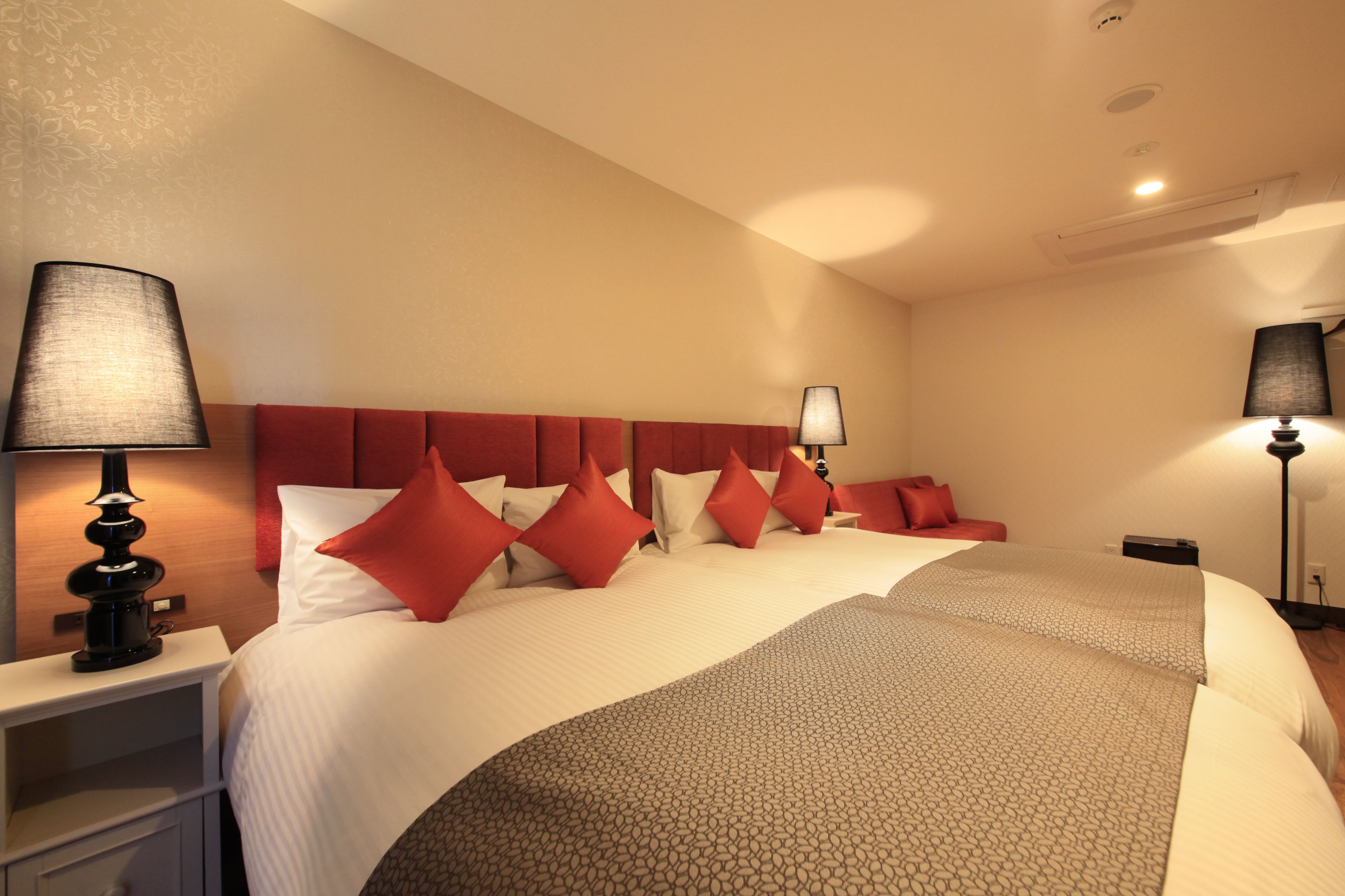 Une chambre d’hôtel avec un grand lit, deux tables de chevet et deux lampes.