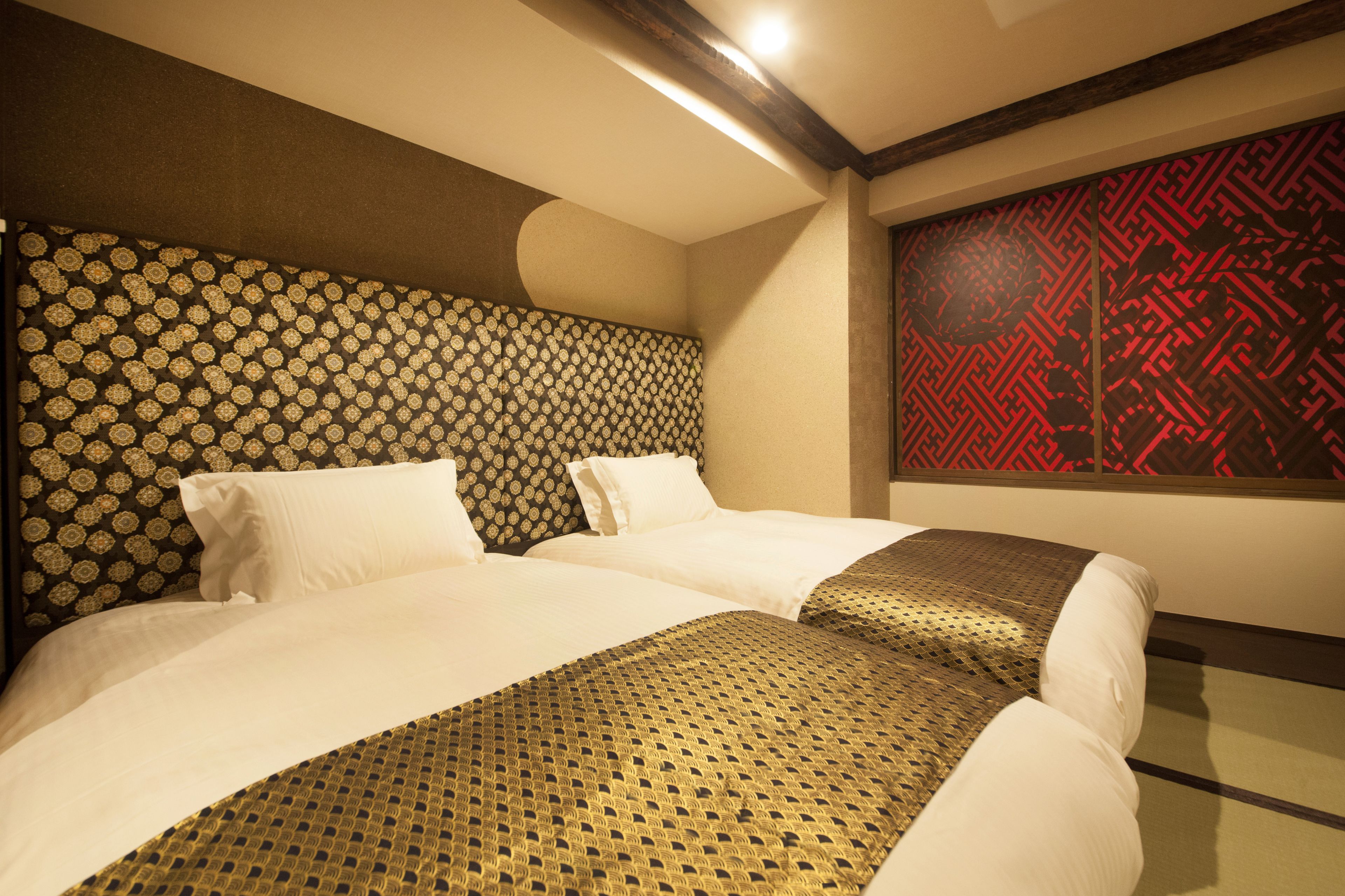A hotel room with a large bed, a patterned headboard, and a decorative wall panel.