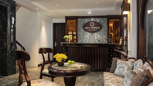 A lobby with a reception desk, seating area, and a marble floor. - Romantique Hotel De Hanoi (Hanoi)