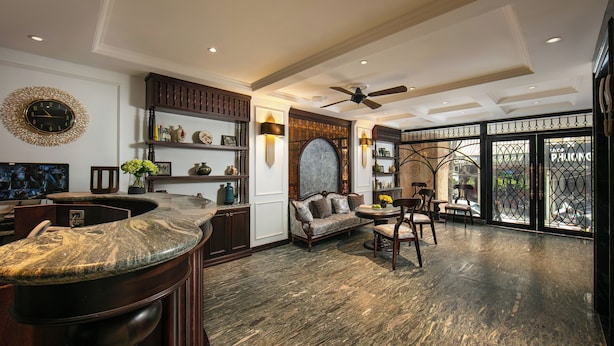 A spacious living area with a marble bar, a comfortable sofa, and a dining set. - Romantique Hotel De Hanoi (Hanoi)