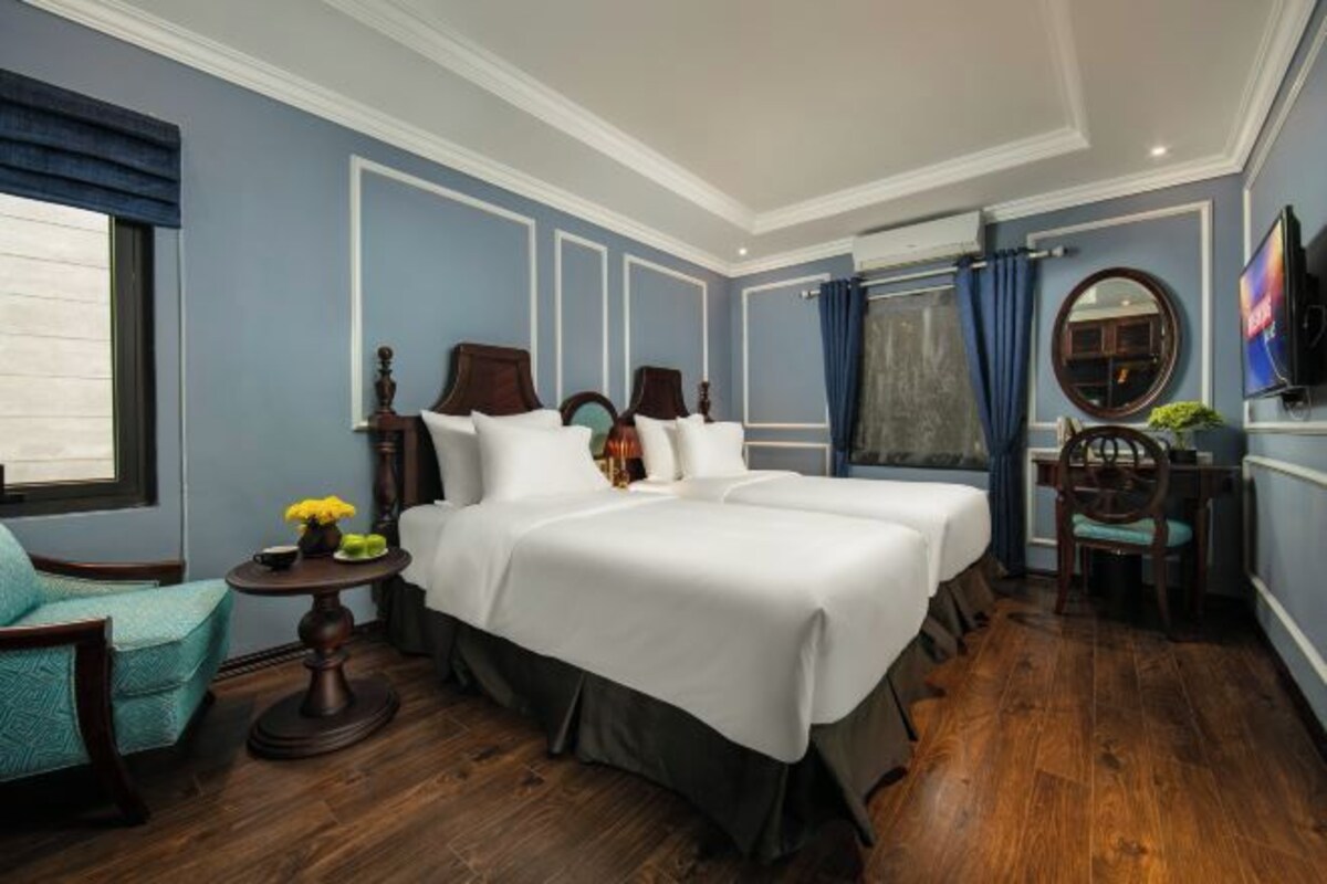 Een hotelkamer met een groot bed, een bureau, een stoel en een televisie.