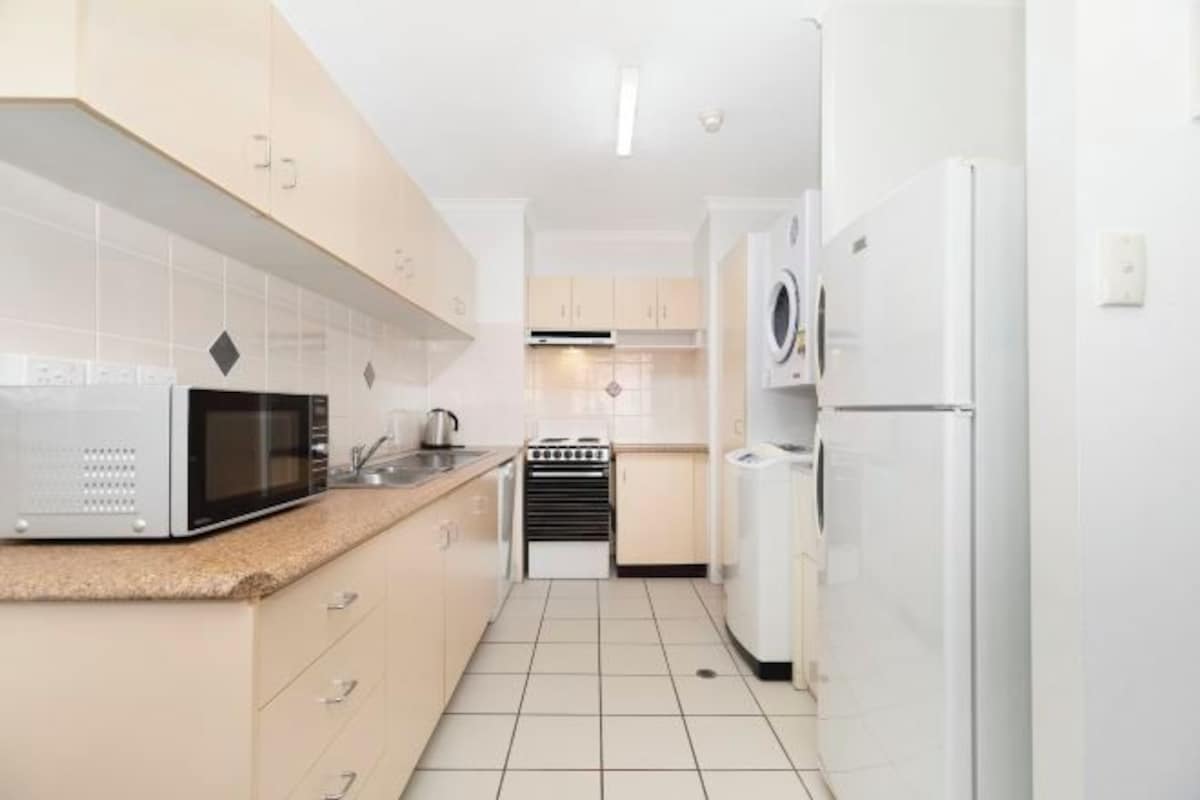 A modern kitchen with white appliances, including a microwave, stove, and refrigerator.