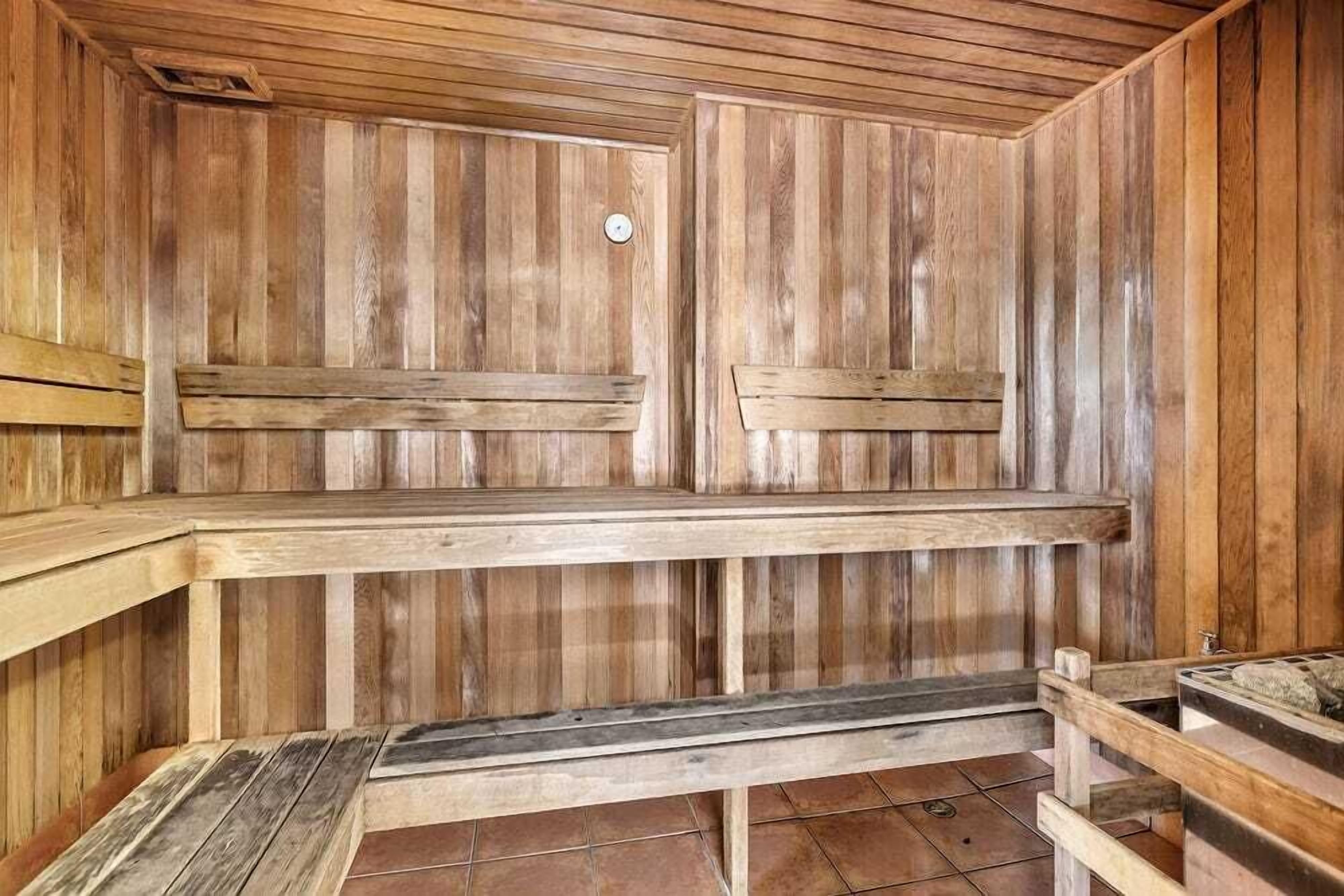 A sauna with wooden benches and a tiled floor.