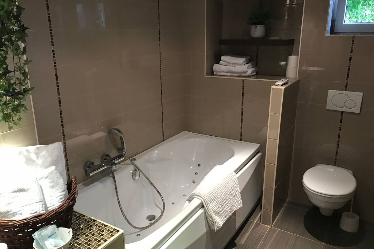family room, jetted tub | bathroom | deep-soaking bathtub, free toiletries, hair dryer, towels