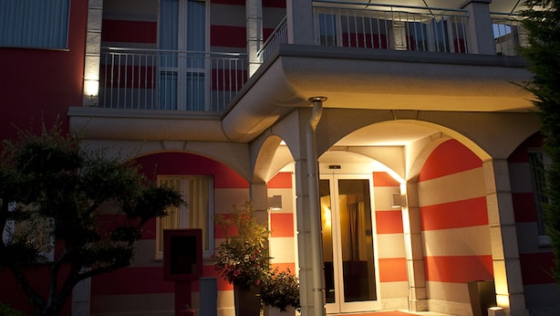 A hotel with a prominent sign reading "HOTEL MEDITERRANEO". It features a multi-story structure with balconies and a covered entrance. - Hotel Mediterraneo (Villa Cortese)