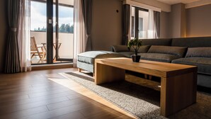 Un salon moderne avec une table basse en bois, un canapé gris et une vue dégagée grâce à de grandes portes-fenêtres coulissantes.
