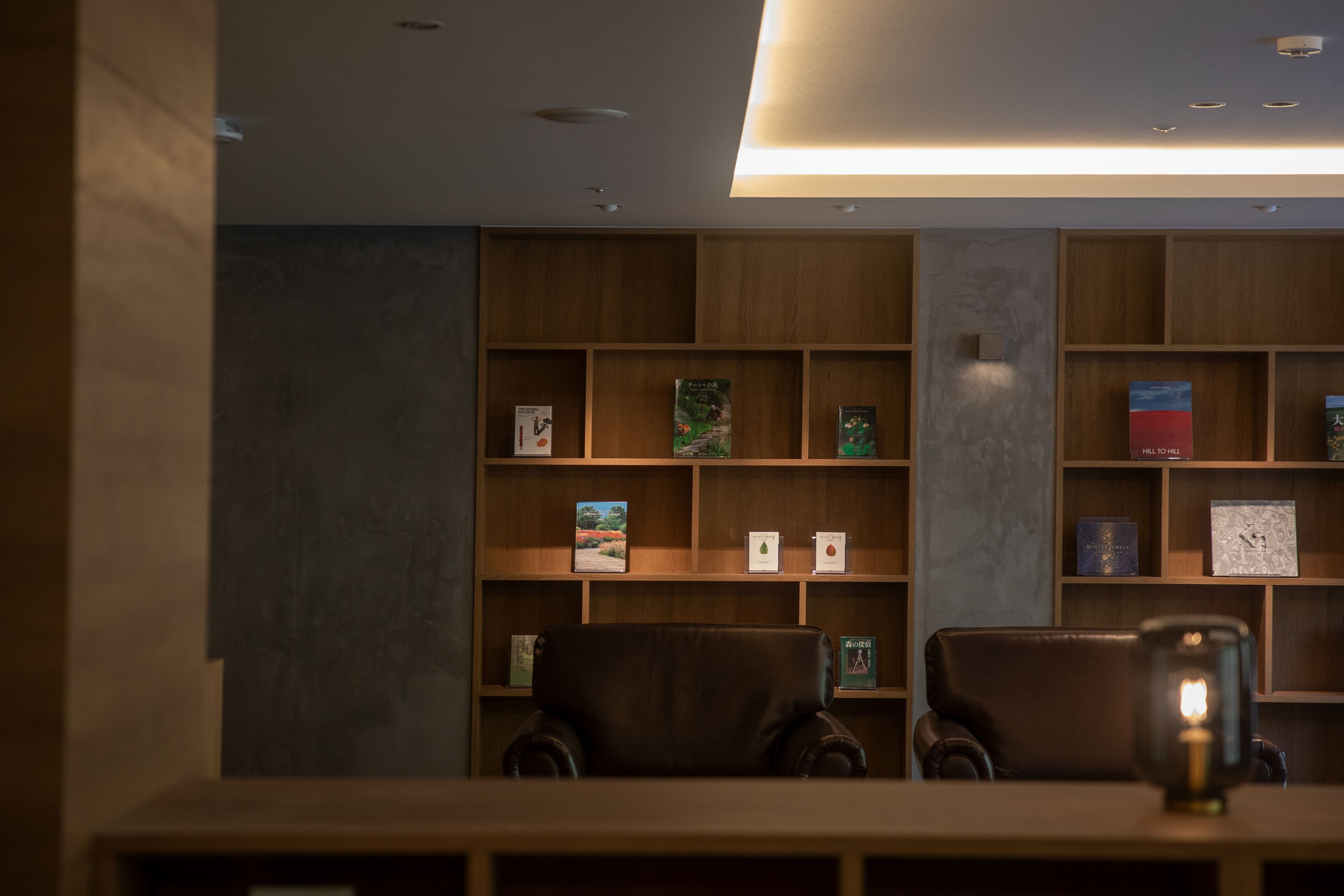 Una biblioteca con estanterías de madera y sillones de cuero.
