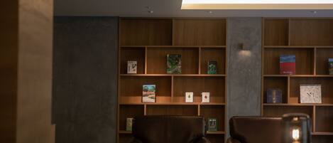 Una biblioteca con estanterías de madera y sillones de cuero.