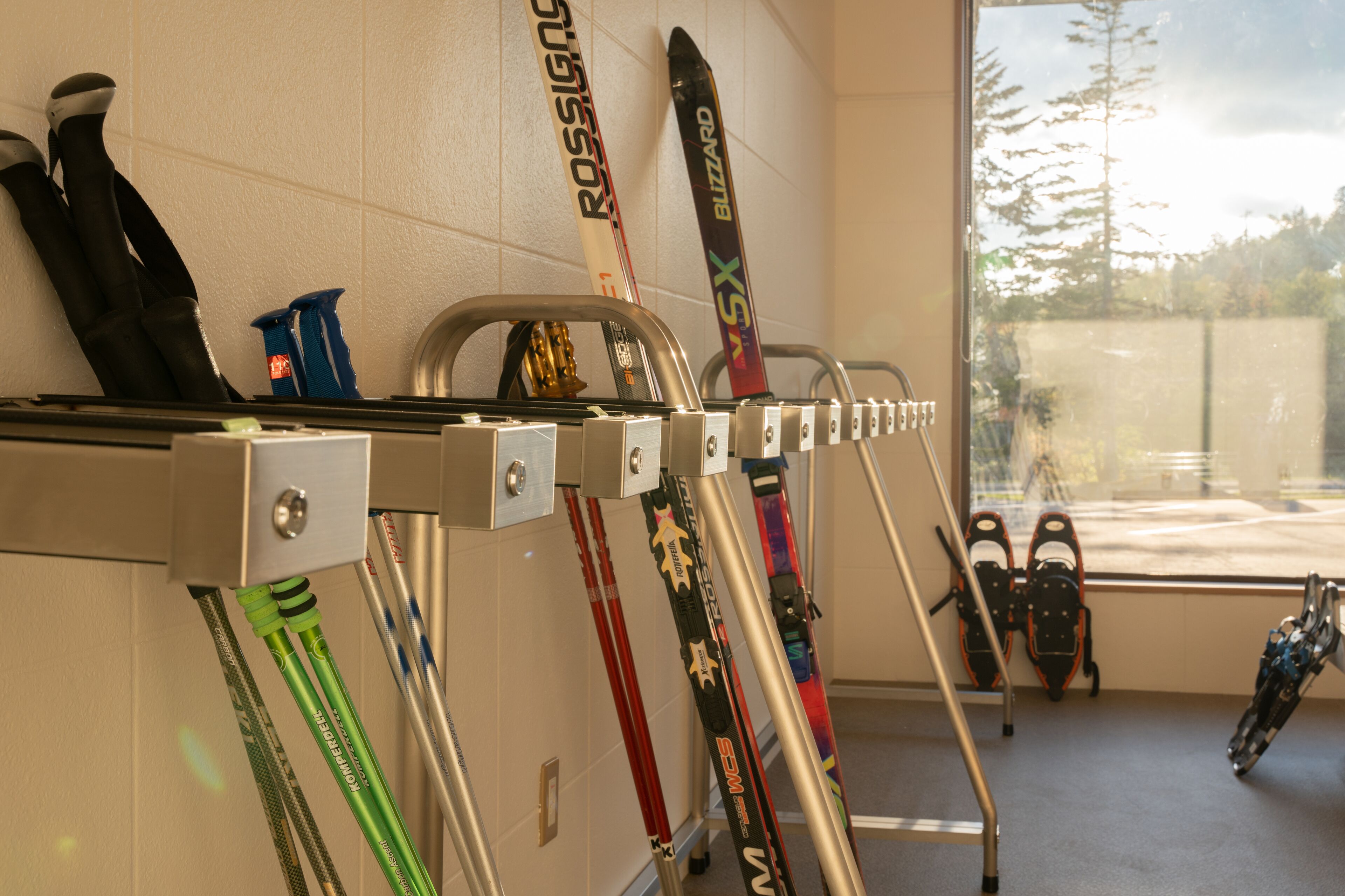 A ski storage rack with skis and ski boots.