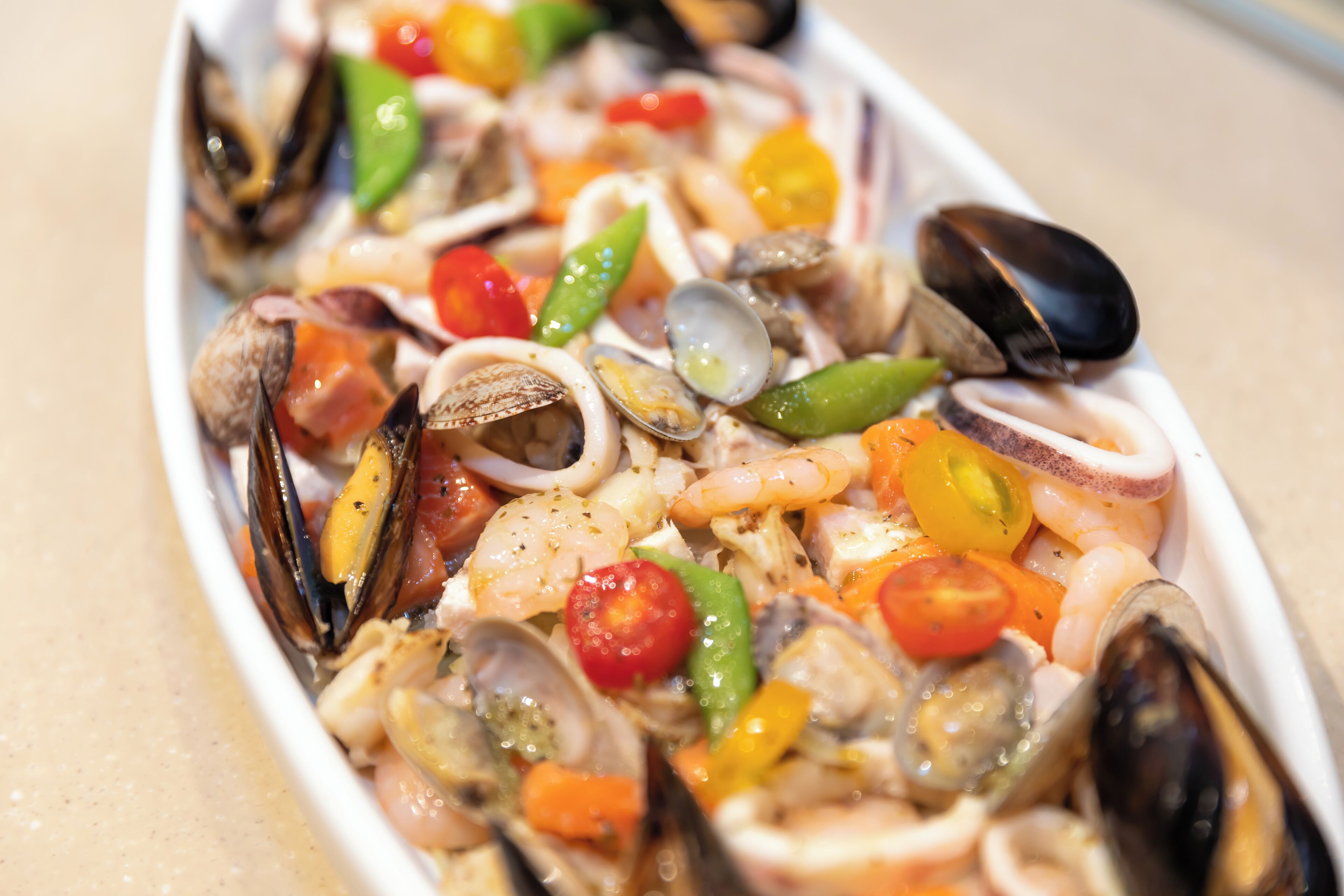 A seafood dish with mussels, clams, shrimp, and cherry tomatoes.