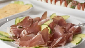 A plate of prosciutto and cucumber slices. - Hotel NearBy (Laatzen)