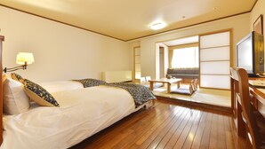 Una habitación de hotel con una cama grande, un escritorio y una televisión.
