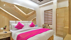 A modern hotel room with a large bed, wooden headboard, and a wardrobe. - Hotel Aman International at New Delhi Station (New Delhi)
