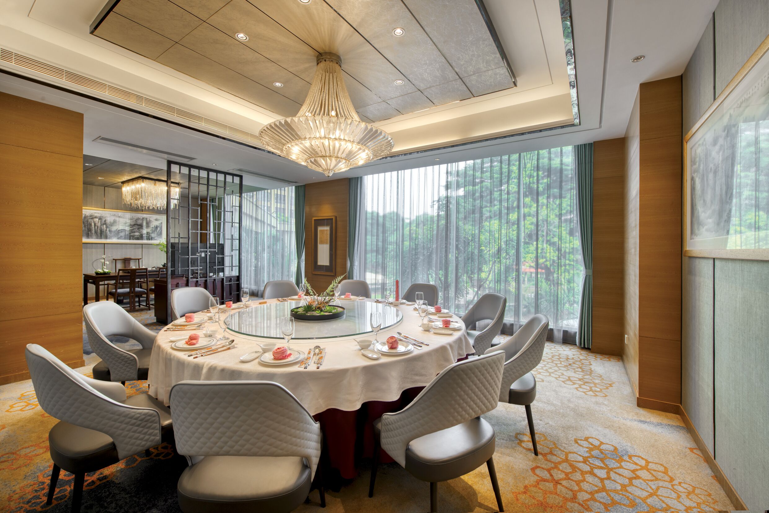 A dining room with a round table, chairs, and a chandelier.