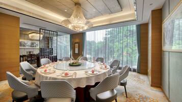 A dining room with a round table, chairs, and a chandelier.
