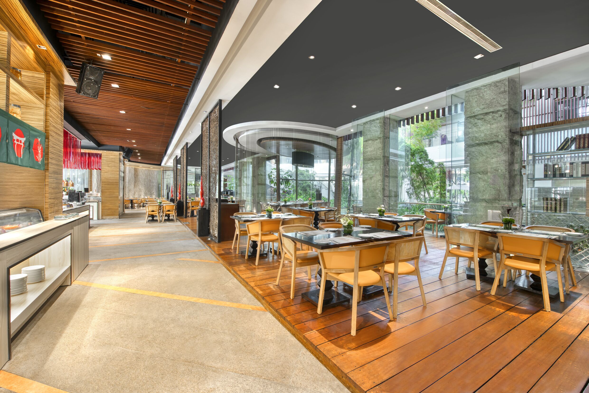 Un restaurante moderno con suelo de madera, paredes de vidrio y diferentes opciones de asientos.