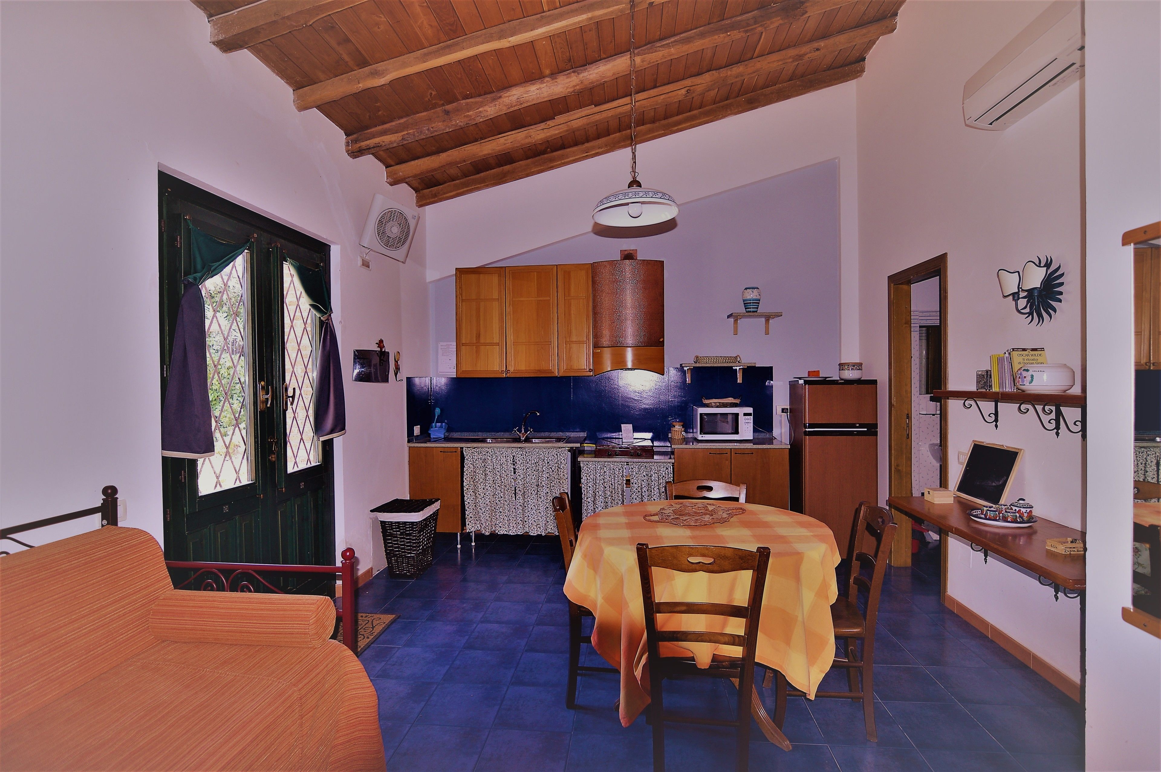 A compact kitchen with wooden cabinets, a dining table, and a small island.