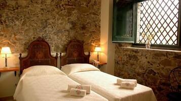 Ein Zimmer mit zwei Betten, Stehwänden und einem Fenster mit Gittermuster.