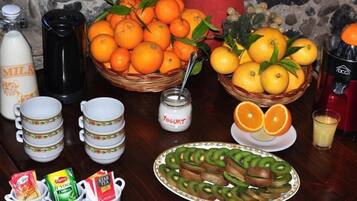 A table with various food items, including oranges, lemons, yogurt, and sliced kiwi.