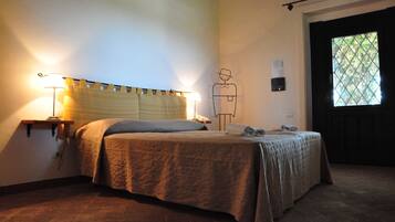 A bedroom with a bed, bedside lamps, a wall clock, and a window with a view.
