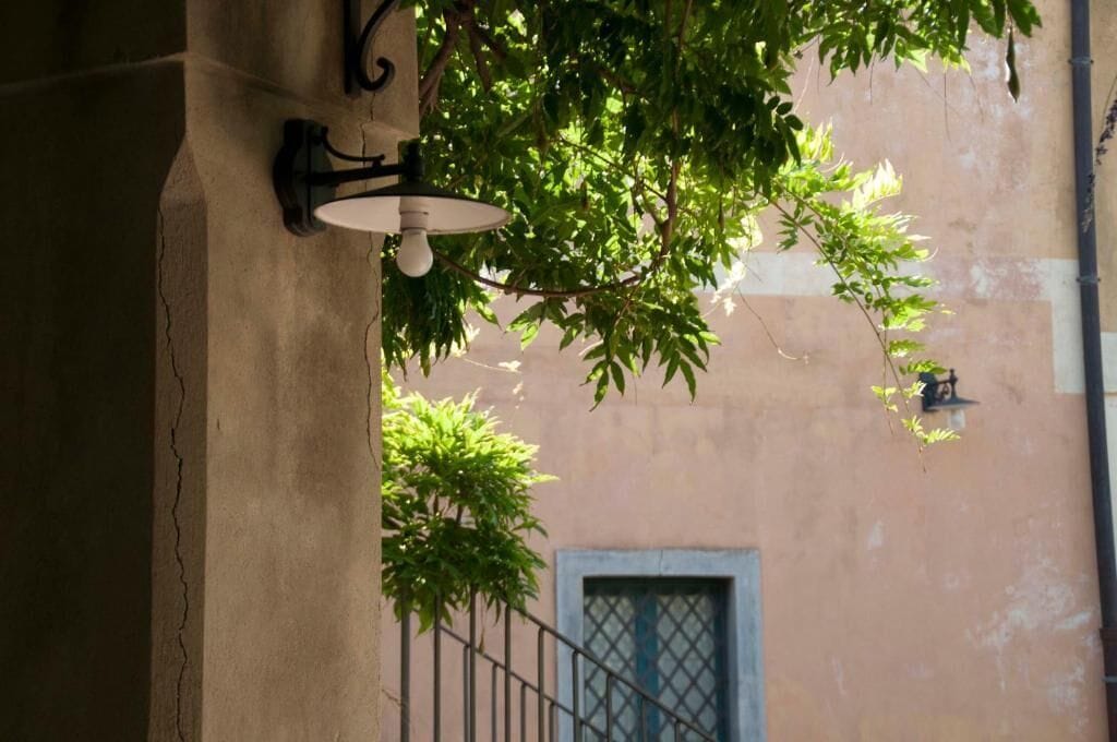 Facciata di un edificio con una finestra e un lampadario a parete.