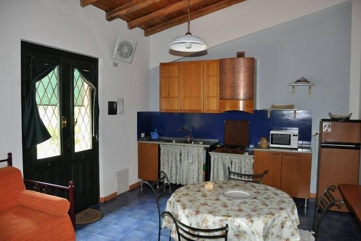 A compact kitchen with wooden cabinets, a microwave, and a sink.
