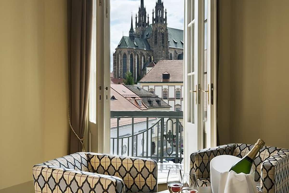 Ein Zimmer mit Blick auf ein Dom, mit gemusterten Möbeln und einem Tisch mit einer Flasche und Gläsern.