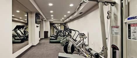 A gym with treadmills, elliptical machines, and weightlifting equipment.