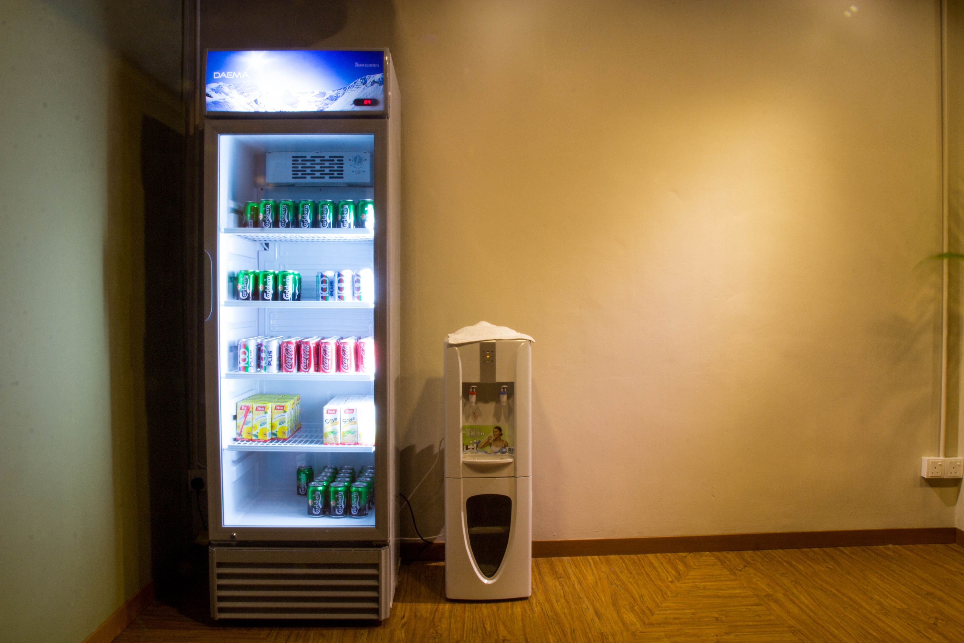 Máquina expendedora con dispensador de bebidas y sección refrigerada con diversas opciones de refrescos.